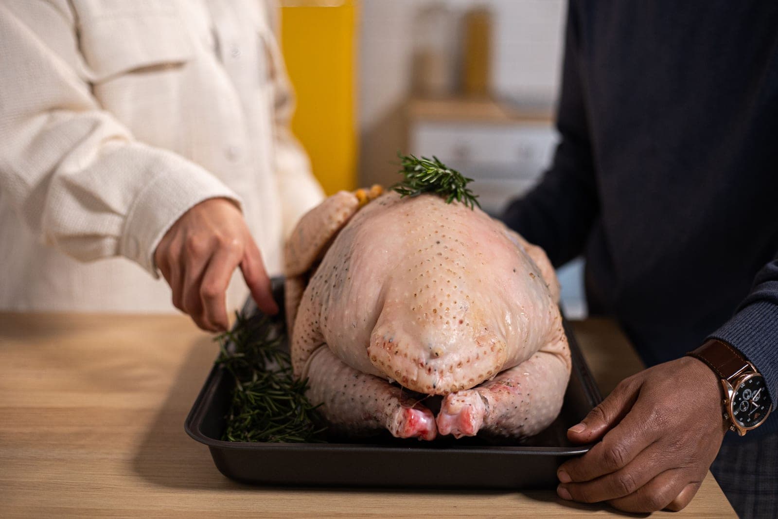 A raw turkey being prepared on a kitchen counter