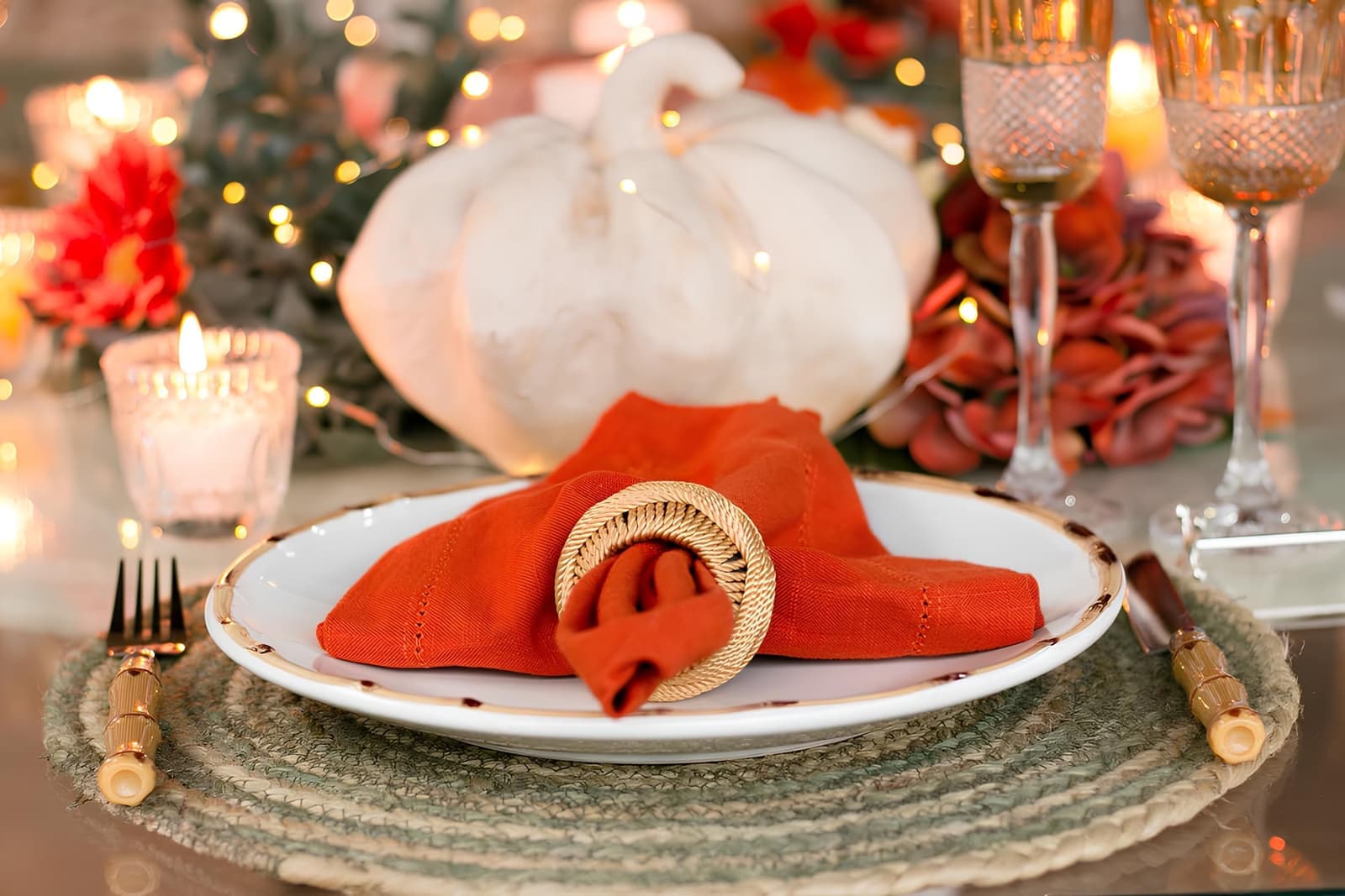 An autumn table setting with warm candlelight and seasonal decorations