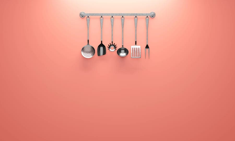 A metal kitchen utensil on a plain surface