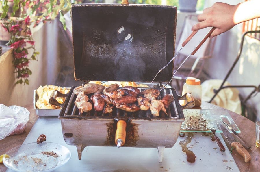 An outdoor cooker with the lid raised