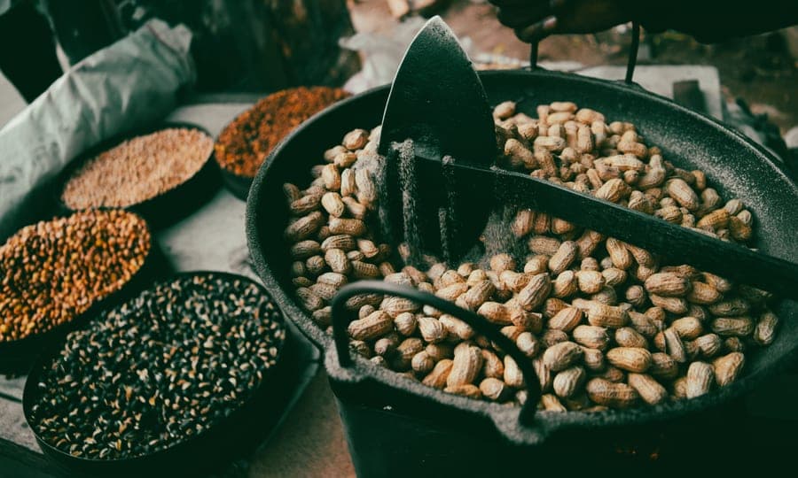 A bowl of peanuts on a wooden surface