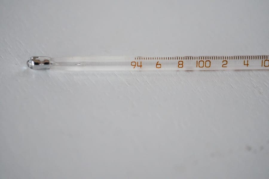 A probe thermometer laid on a wooden board